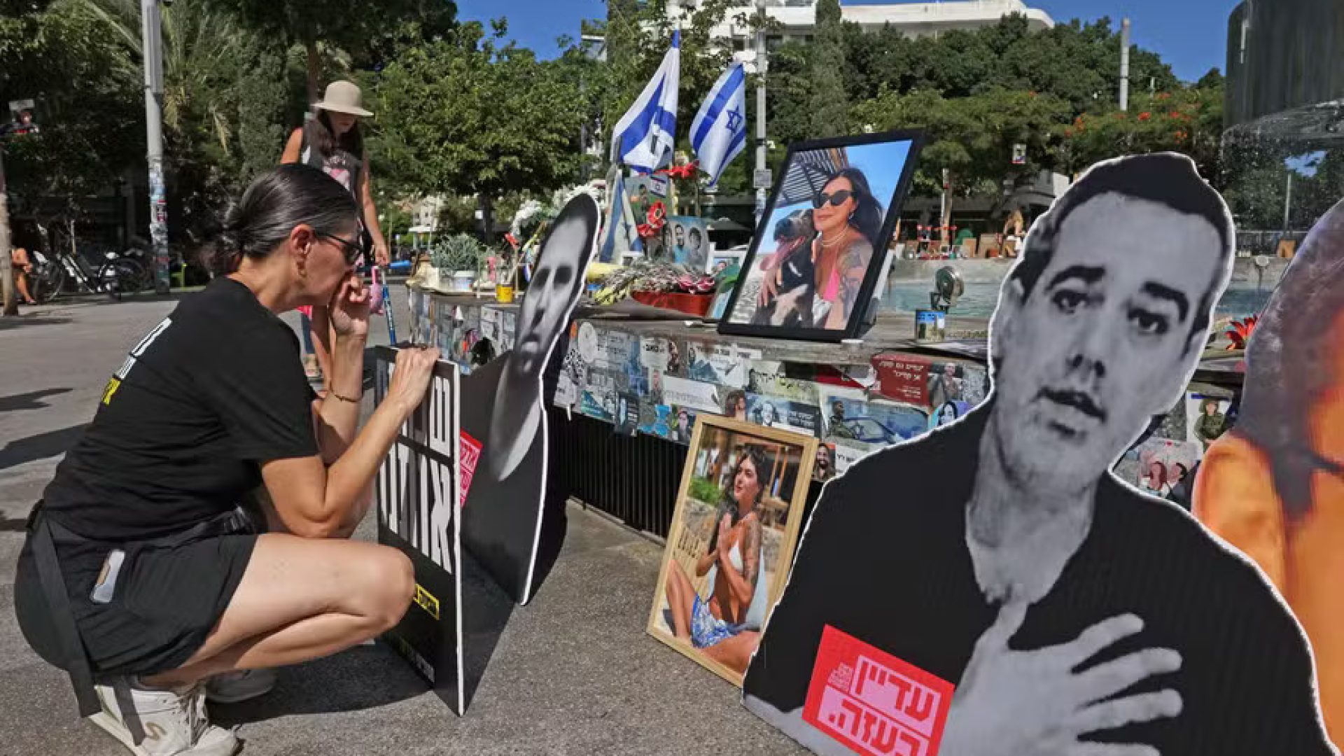 112624115-people-gather-around-a-fountain-turned-to-a-memorial-in-tel-aviv-for-israelis-killed-durin.jpeg