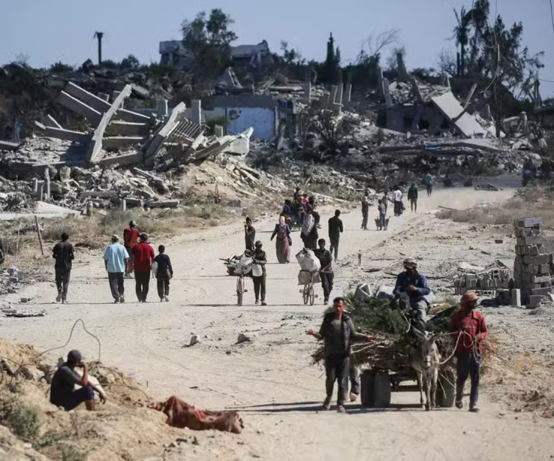 112692580-topshot-displaced-palestinians-walk-past-destroyed-buildings-as-they-return-to-their-hom.j.jpeg