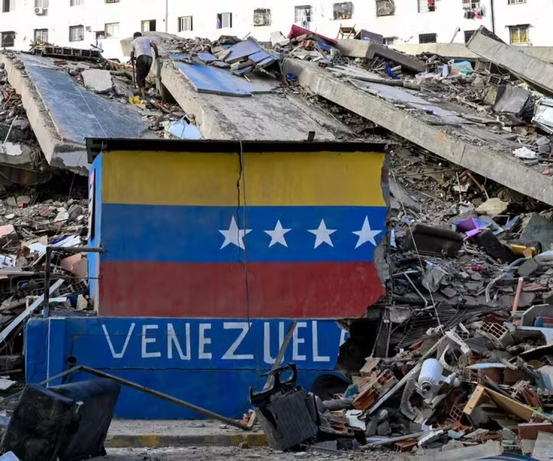 115455424-a-venezuelan-flag-is-seen-painted-on-a-damaged-wall-amid-the-rubble-of-a-collapsed-buildin.jpeg