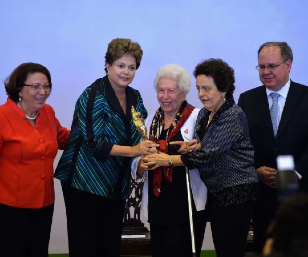 Clara entre a ex-presidente Dilma Rousseff e a ex-ministra Eleonora Menicucci ao ser premiada, em 2014 -  (crédito: Wilson Dias/Agência Brasil)