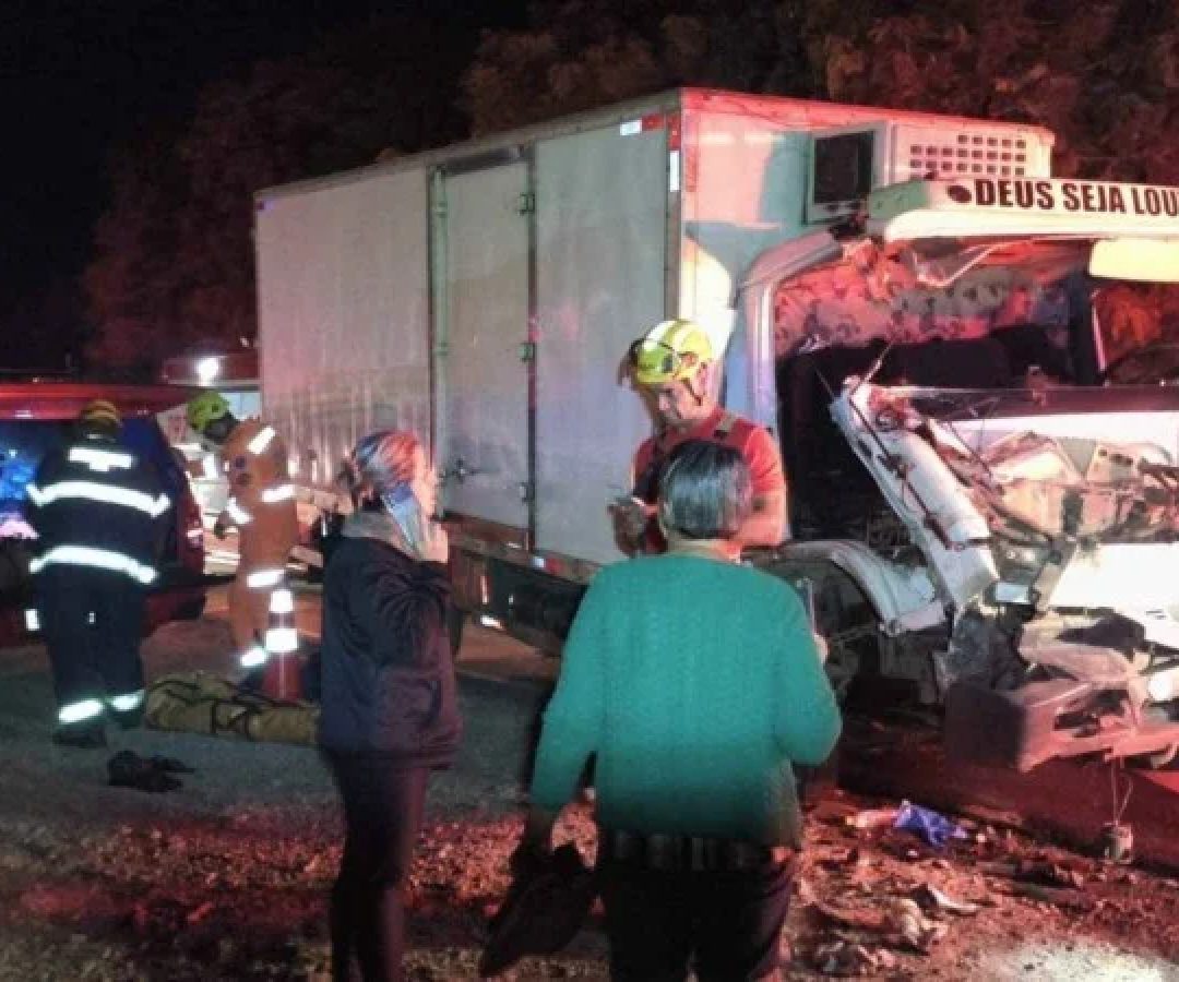 Caminh&atilde;o ficou com a parte frontal destru&iacute;da ao bater em uma carreta. O passageiro de 26 anos ficou preso nas ferragens da cabine e o motorista saiu ferido -  (crédito: CBMMG)