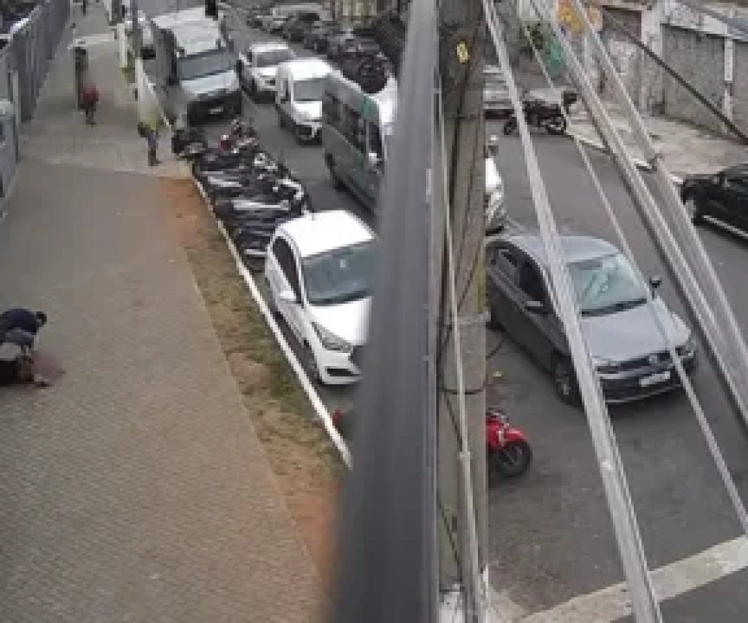 O agressor, em cima da vítima, deitada no chão, durante caso que ocorreu no centro de São Paulo -  (crédito: Reprodução / YouTube /  PMSP - Acervo)