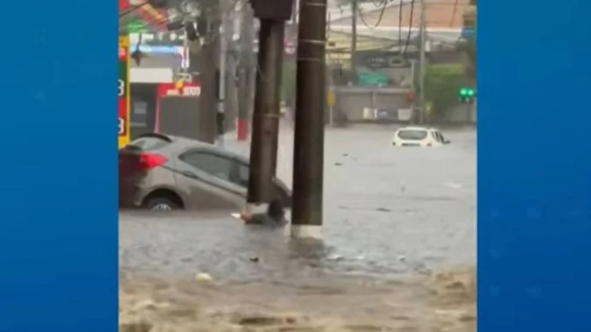 A mulher de 60 anos agarrada em um poste antes de ser arrastada pela enxurrada durante o temporal -  (crédito:  ReproduÃ§Ã£o / TV Band)