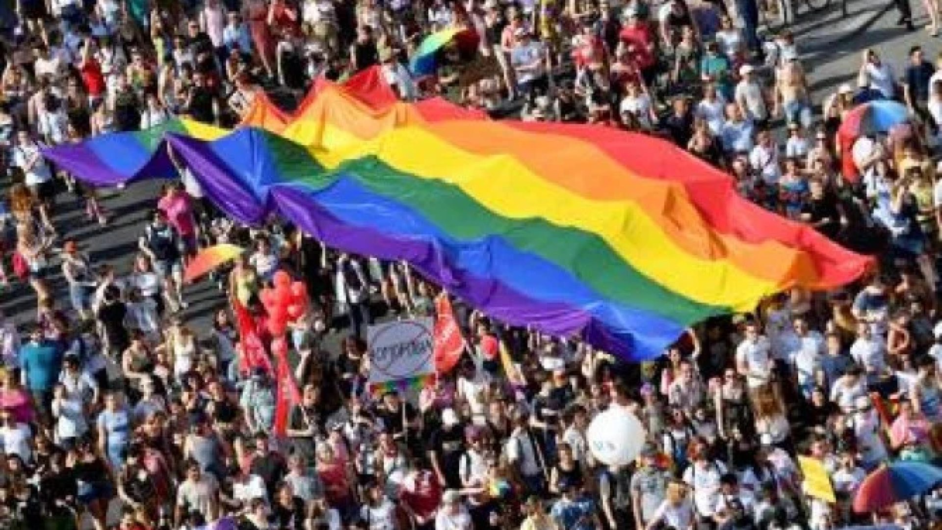 (FILES) In this file photo taken on July 06, 2019 people march with their giant rainbow flag during the lesbian, gay, bisexual and transgender (LGBT) Pride Parade from the parliament building in downtown Budapest. Hungary