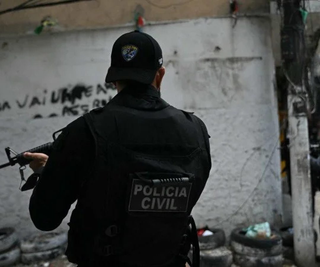 Policiais se abrigam durante a Operação Contenção na favela Vila Cruzeiro, no complexo da Penha, no Rio de Janeiro, Brasil, em 28 de outubro de 2025 -  (crédito: MAURO PIMENTEL / AFP)