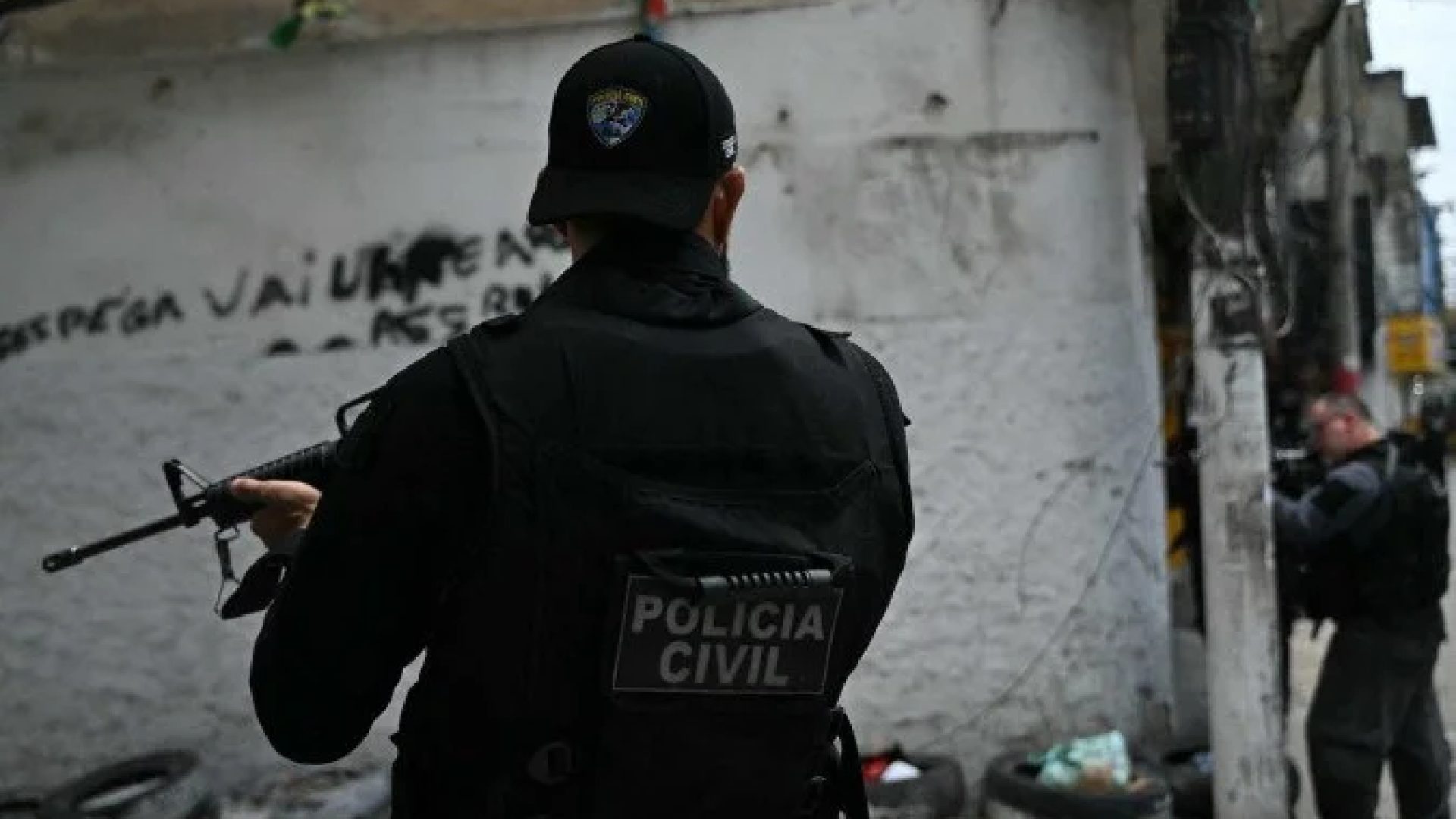 Policiais se abrigam durante a Operação Contenção na favela Vila Cruzeiro, no complexo da Penha, no Rio de Janeiro, Brasil, em 28 de outubro de 2025 -  (crédito: MAURO PIMENTEL / AFP)