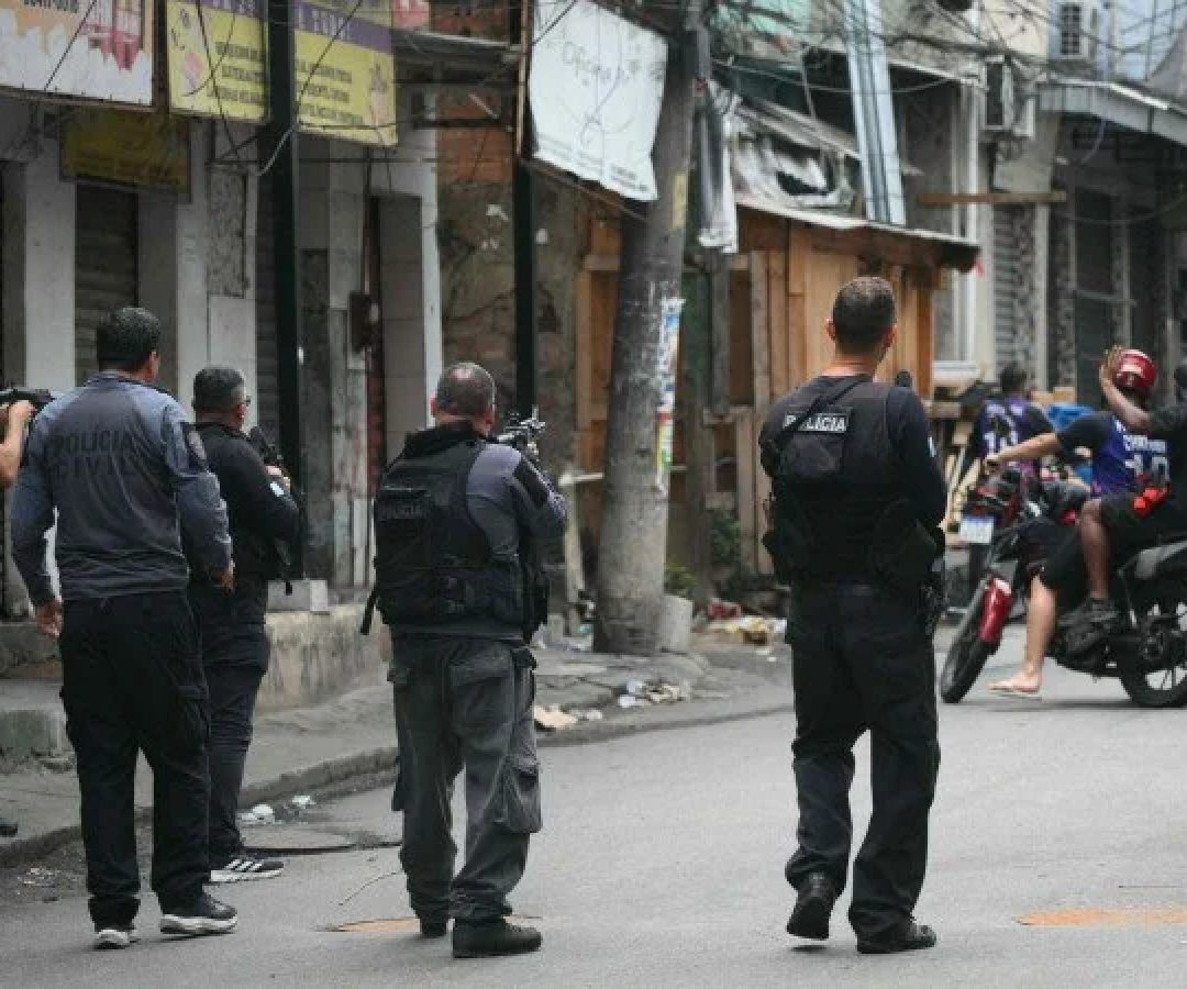 Policial faz sinal para motociclistas darem marcha ré durante a Operação Contenção na favela Vila Cruzeiro, no complexo da Penha, no Rio de Janeiro, Brasil, em 28 de outubro de 2025       -  (crédito: MAURO PIMENTEL / AFP)