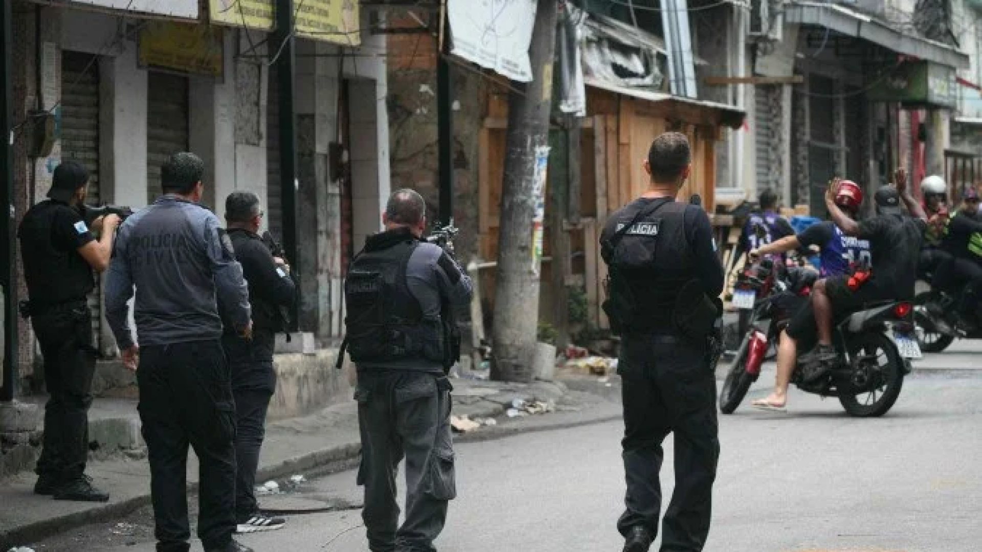 Policial faz sinal para motociclistas darem marcha ré durante a Operação Contenção na favela Vila Cruzeiro, no complexo da Penha, no Rio de Janeiro, Brasil, em 28 de outubro de 2025       -  (crédito: MAURO PIMENTEL / AFP)
