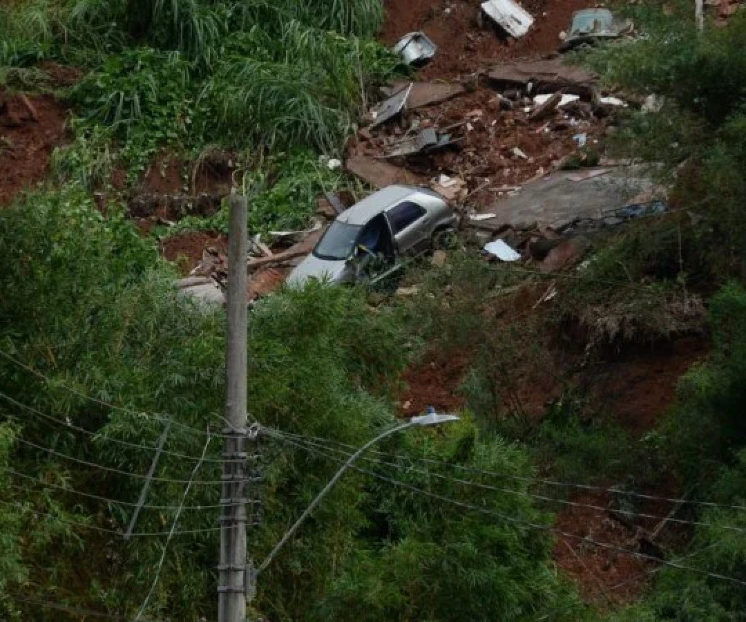 No bairro Jardim Natal, em Juiz de Fora, seis residências foram invadidas pela enchente. Pessoas limpam suas casas, removem móveis e utensílios, máquinas tentam desobstruir o leito do córrego que está repleto de destroços -  (crédito: Túlio Santos/EM/D.A Press)