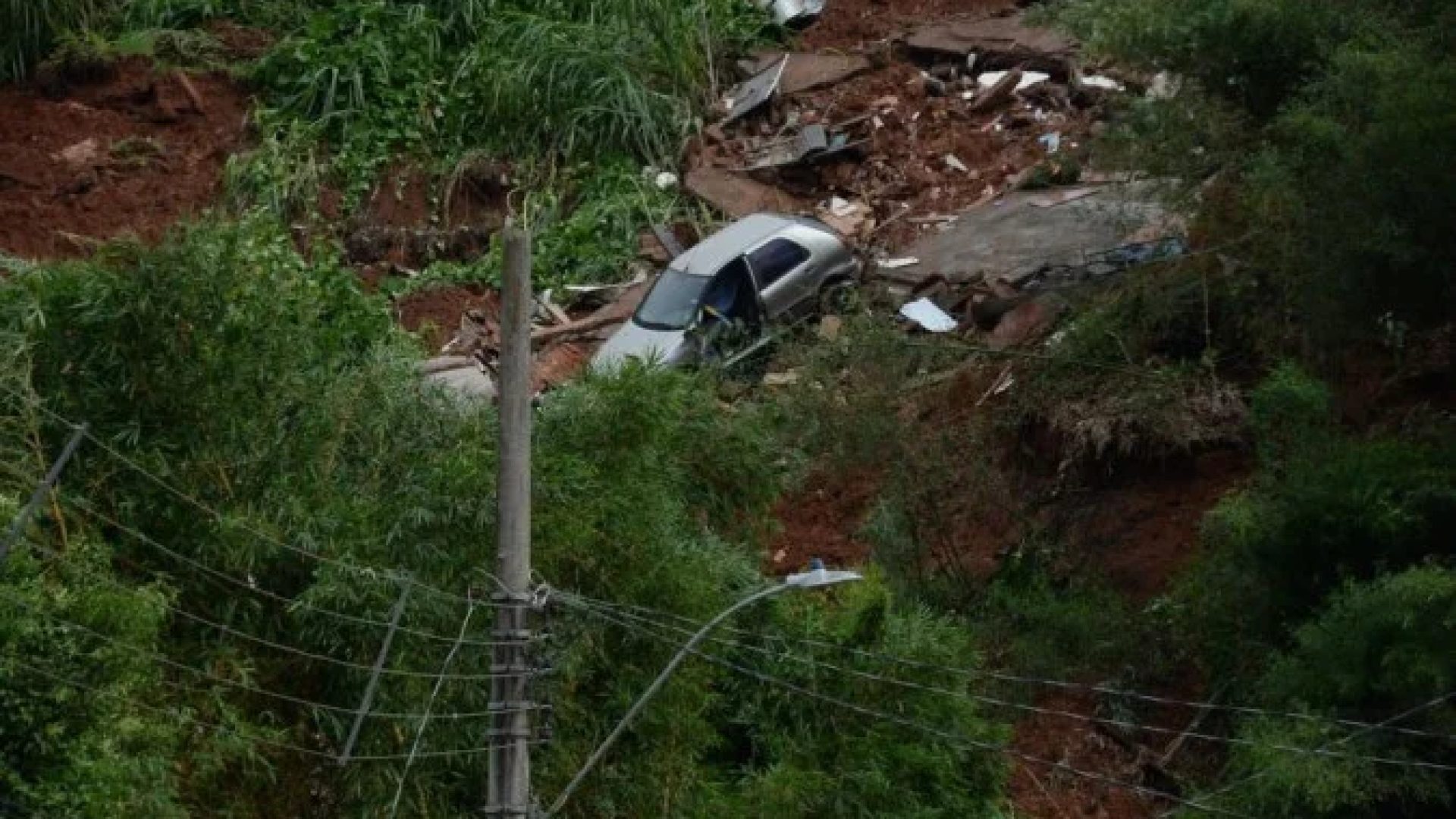 No bairro Jardim Natal, em Juiz de Fora, seis residências foram invadidas pela enchente. Pessoas limpam suas casas, removem móveis e utensílios, máquinas tentam desobstruir o leito do córrego que está repleto de destroços -  (crédito: Túlio Santos/EM/D.A Press)