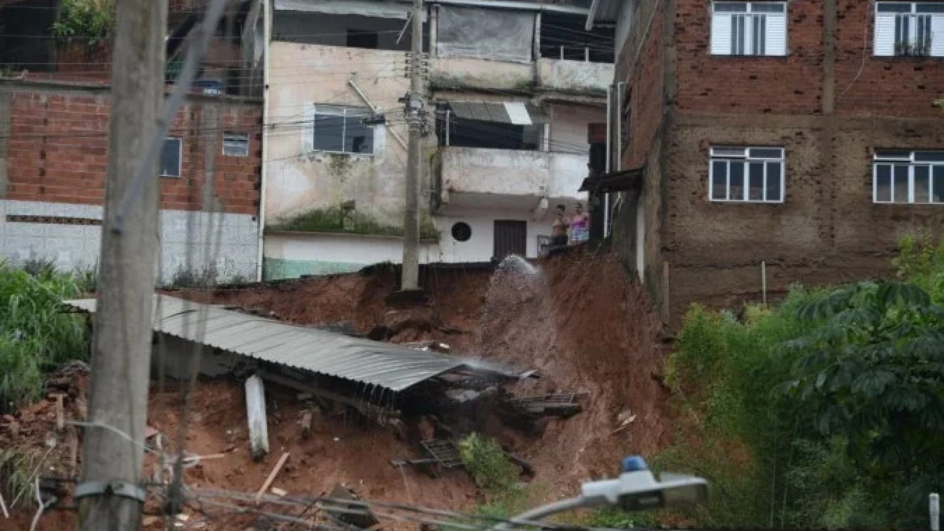 No bairro Jardim Natal, em Juiz de Fora, seis resid&ecirc;ncias foram invadidas pela enchente. Pessoas limpam suas casas, removem m&oacute;veis e utens&iacute;lios, m&aacute;quinas tentam desobstruir o leito do c&oacute;rrego que est&aacute; repleto de destro&ccedil;os -  (crédito: T&uacute;lio Santos/EM/D.A Press)