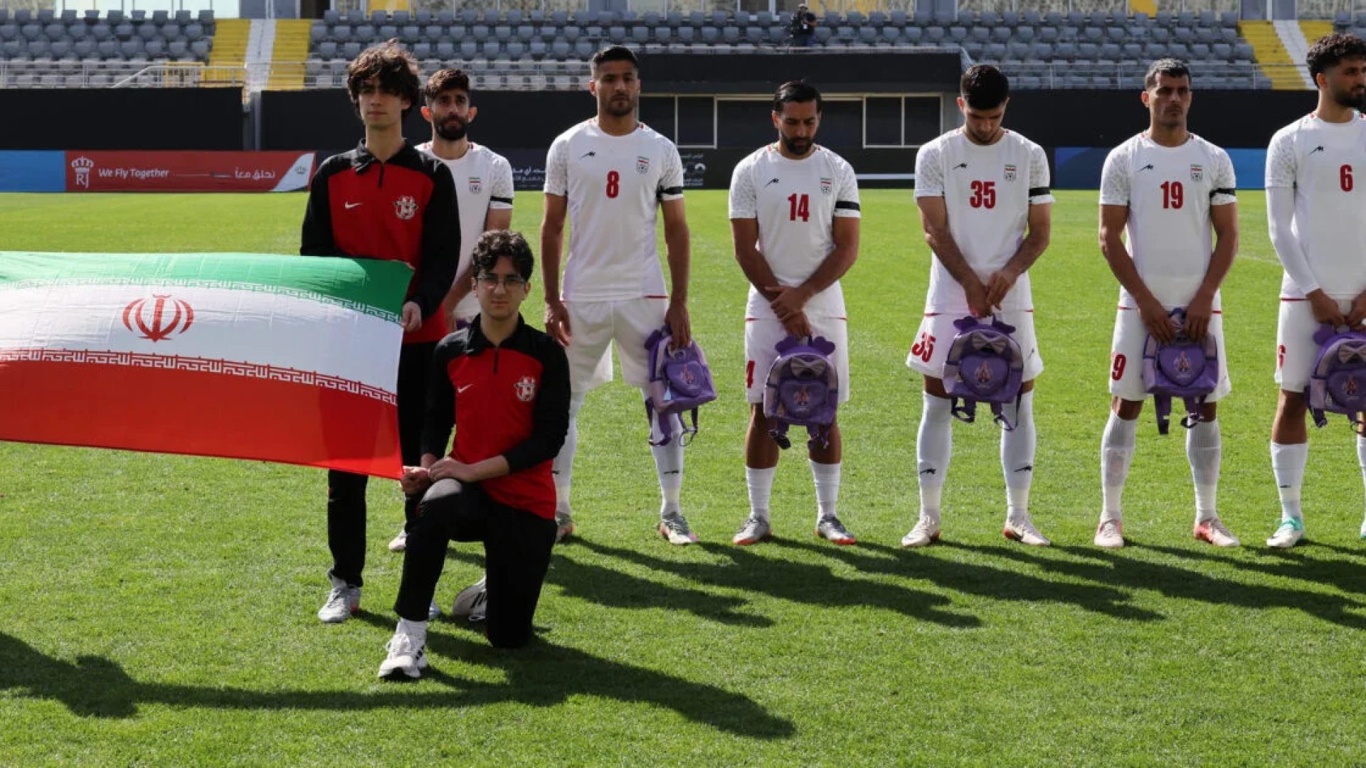 Jogadores iranianos de futebol seguram mochilas escolares em protesto