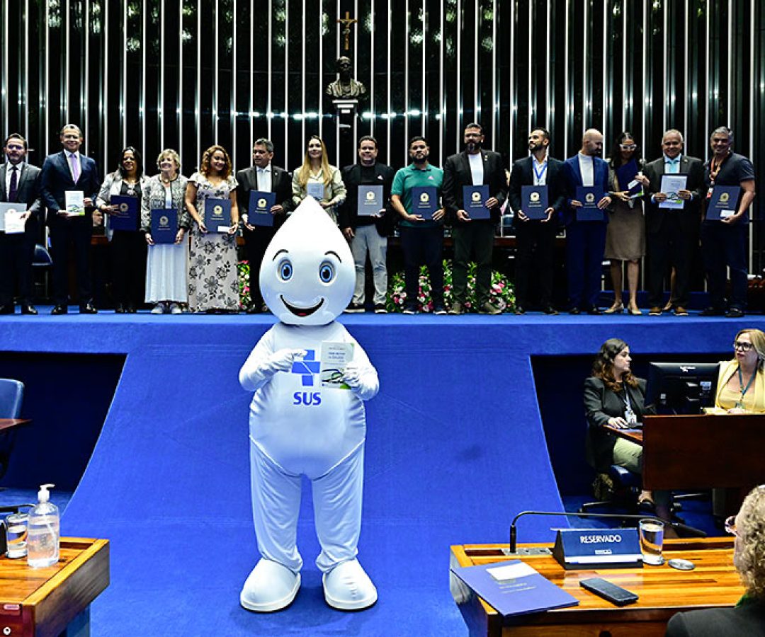 Zé Gotinha posa para foto com parlamentares e convidados.