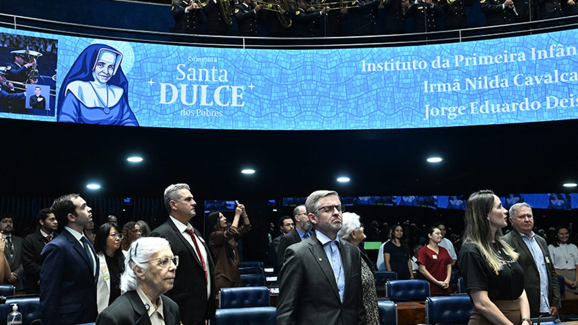 Em posição de respeito, parlamentares e convidados acompanham execução do Hino Nacional pela Banda de Música da Marinha do Brasil.