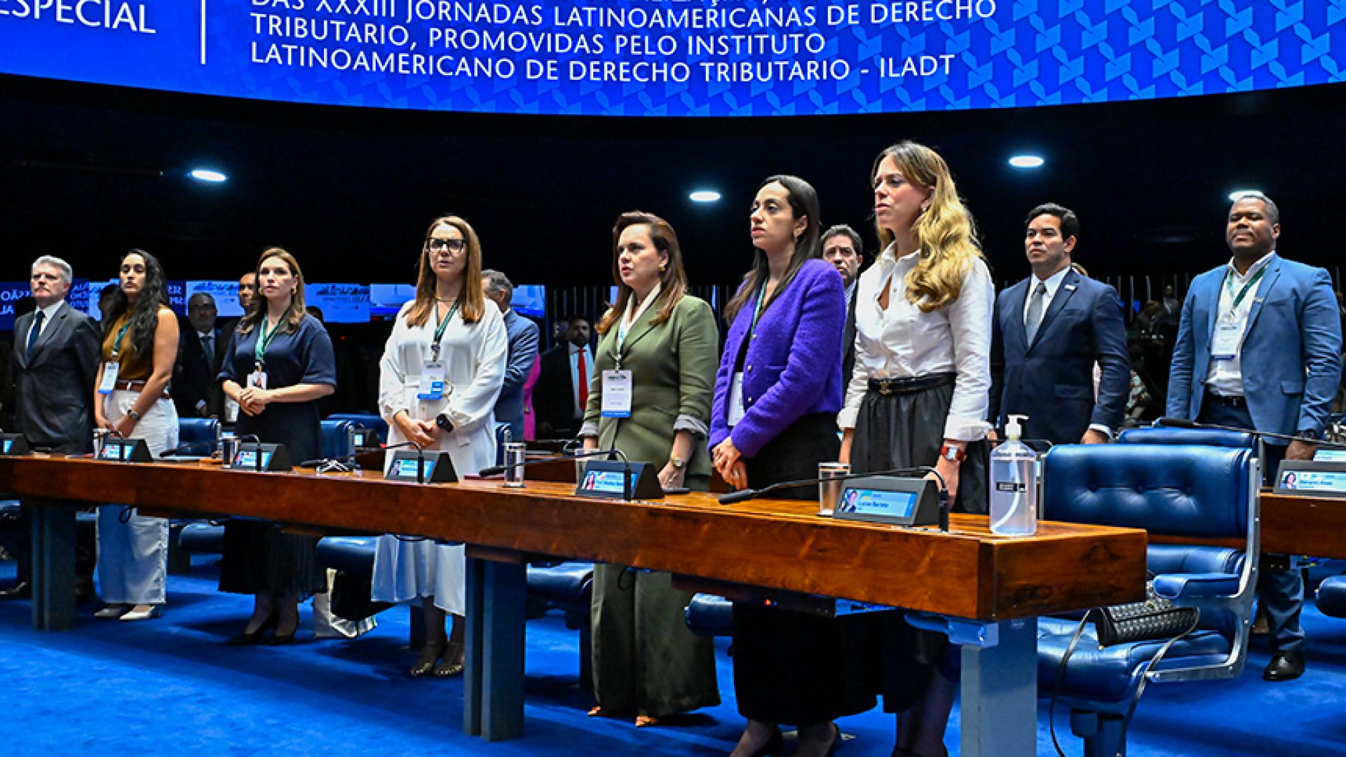 Em posição de respeito, parlamentares e convidados acompanham execução do Hino Nacional.