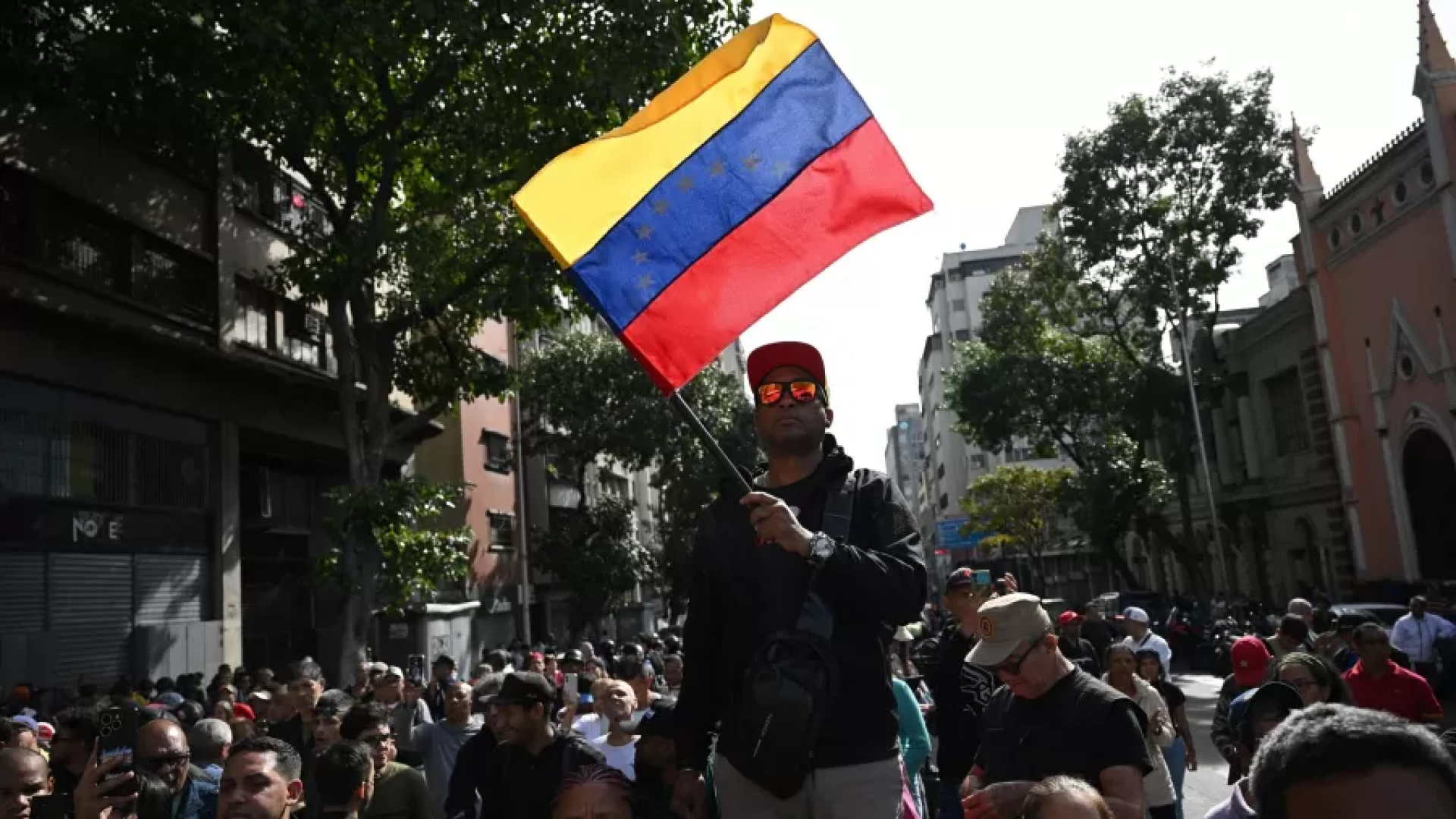 3jan2026-um-apoiador-do-presidente-nicolas-maduro-segura-uma-bandeira-da-venezuela-durante-uma-manif.png