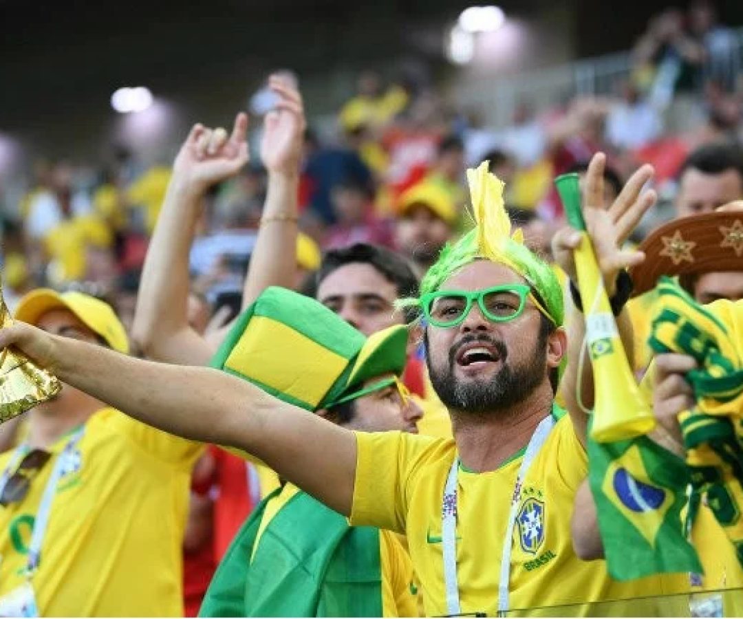 Torcedores brasileiros na arquibancada do estádio se preparam para acompanhar o jogo
